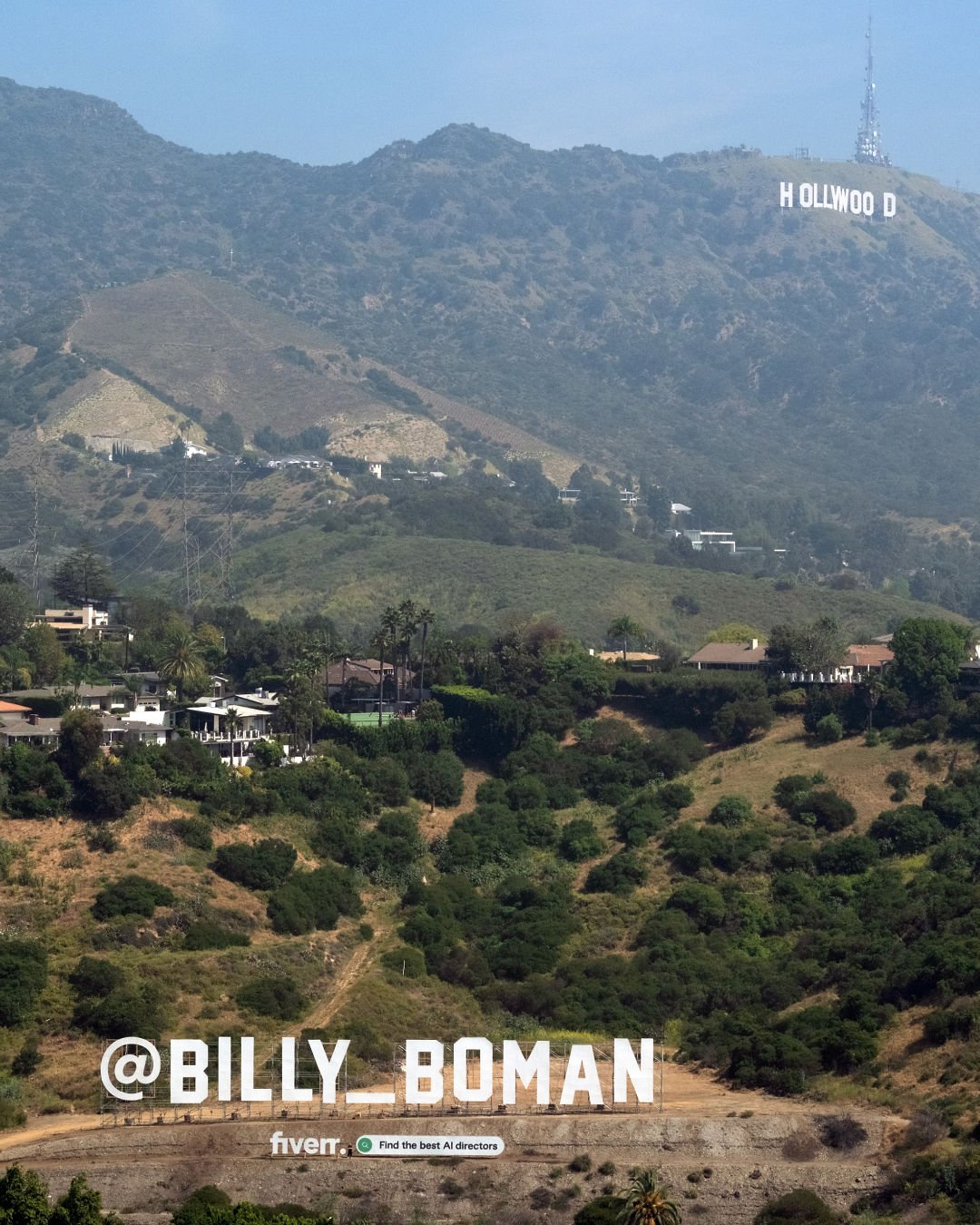 A photo of the Hollywood Hills. The iconic Hollywood sign is in the background and in the foreground at the bottom of the shot is another large white sign that reads 'Billy Bomon'. The photo is of a stunt from Fiverr.