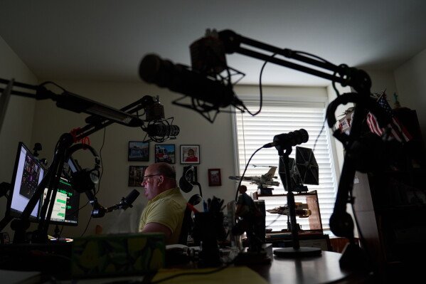 Brian Glick, who is fighting to recover the $575,000 stolen from him by a scammer online, joins a group call with other scam victims at his home where he also produces a podcast on the subject, Wednesday, June 25, 2025, in Ballston Lake, N.Y. (AP Photo/David Goldman)