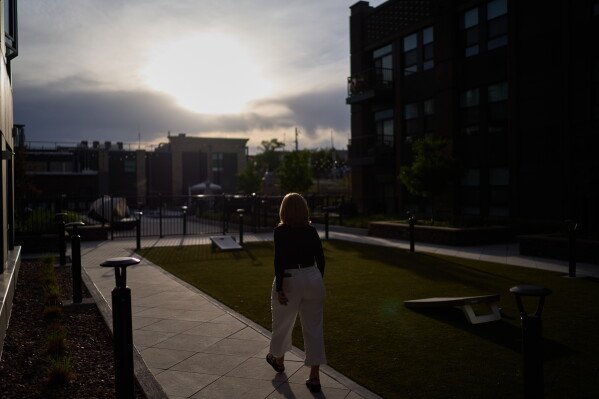 Debra Fox, who had $58,000 stolen from her in a romance scam, goes for a walk outside her apartment complex, Wednesday, May 13, 2026, in Arvada, Colo. (AP Photo/David Goldman)