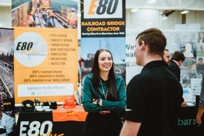 A recruiter for a railroad bridge contracting company smiles at a student job seeker during a conversation at Career Fair.